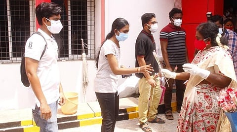 புதுச்சேரியில் கரோனா தடுப்பூசி செலுத்த வந்த இளையோருக்கு பூங்கொத்து தந்து வரவேற்கும் ஆளுநர் தமிழிசை