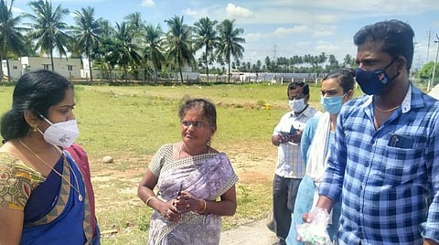 வேடசந்தூர் அருகே வீட்டில் கரோனா தடுப்பூசி செலுத்தப்பட்டது குறித்து விசாரணை மேற்கொண்ட பொன்மேகேஸ்வரி (இடது). மகப்பேறு உதவியாளர் தனலட்சுமி (நடுவில்).