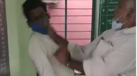 விவசாயி கோபால்சாமியைத் தாக்கும் கிராம உதவியாளர் முத்துசாமி.
