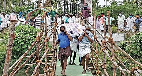 கோபி அருகே இறந்தவரின் சடலத்தை அடக்கம் செய்ய, கீரிப்பள்ளம் ஓடையில் தற்காலிக பாலம் அமைத்து எடுத்துச்  செல்லும் பொதுமக்கள்.