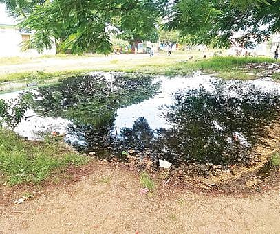 குடியாத்தம் அடுத்த அக்ராவரம் அரசு மேல்நிலைப் பள்ளியின் நுழைவு வாயில் வழியாக ஓடும் கழிவுநீர். அடுத்த படம்: பள்ளி மைதானத்தில் குளம் போல் தேங்கி துர்நாற்றம் வீசும் கழிவுநீர்.