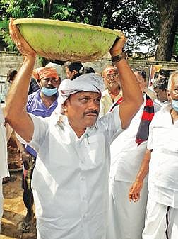 திட்டக்குடியில் நேற்று   தூய்மைப் பணியில் ஈடுபட்ட அமைச்சர் சி.வெ.கணேசன், மண் பாண்டு சுமந்து செல்கிறார்.