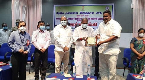 அதிக முறை ரத்த தானம் செய்த தன்னார்வலருக்கு நினைவுப் பரிசு சான்றிதழைத் தருகிறார் முதல்வர் ரங்கசாமி. அருகே சுகாதாரத்துறை அதிகாரிகள்.