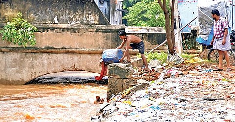 ஆக்கிரமிப்பு கட்டிடங்களால் வெள்ள நீர் வழிந்தோட வழியின்றி திணறும் தோவாளை கால்வாய். (அடுத்த படம்) வெள்ளத்தால் சேதம் ஏற்பட்ட பிறகும் தோவாளை கால்வாய்க்குள் கழிவுகளை கொட்டும் அவலம் தொடர்கிறது.  				         படங்கள்: மு. லெட்சுமி அருண்