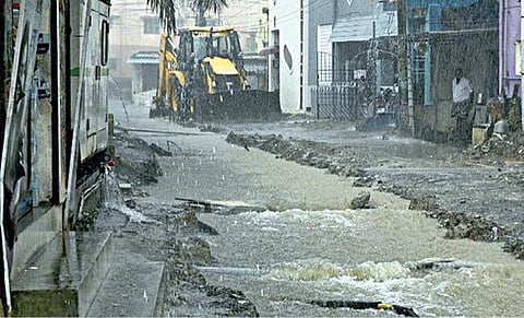 படூரில் சாலையை பெயர்த்து அமைக்கப்பட்டுள்ள கால்வாயில் ஈசா ஏரியின் உபரிநீர் வெளியேறி வருகிறது. படம்: எம்.முத்துகணேஷ்.