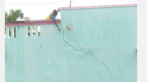 குடியாத்தம் அடுத்த தட்டப்பாறை மீனூர் கொல்லைமேடு பகுதியில் செல்வம் வீட்டில் ஏற்பட்ட விரிசலை அவரது மனைவி லதா சுட்டிக்காட்டினார்.  | படம். வி.எம்.மணிநாதன்.