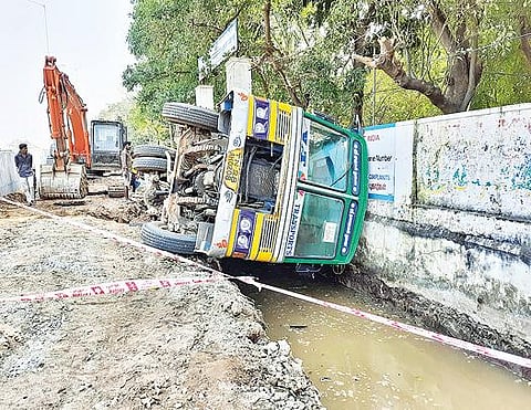திருவண்ணாமலை கோட்டாட்சியர் அலுவலகம் முன்பு கழிவுநீர் கால்வாய் அமைக்கும் பணியில் ஈடுபட்ட லாரி கவிழ்ந்து விபத்துக்குள்ளானது. படம்: இரா.தினேஷ்குமார்.