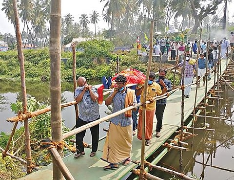 கோபி கிரிப்பள்ளம் ஓடையில் தற்காலிக பாலம் அமைத்து இறந்தவரின் உடலை மயானத்திற்கு எடுத்துச் செல்லும் பொதுமக்கள்.