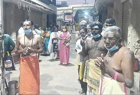 கரோனா கட்டுப்பாடு காரணமாக பக்தர்கள் வழிபாடு நடத்த அனுமதி மறுக்கப்பட்டதால் திருநெல்வேலி நெல்லையப்பர் கோயில் வாசலில் நின்று வழிபட்ட பக்தர்கள். படம்:  என்.ராஜேஷ்