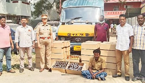 கடலூரில் மதுவிலக்கு அமல் பிரிவு போலீஸாரால் பறிமுதல் செய்யப்பட்ட போலி மது பாட்டில்களுடன் கைது செய்யப்பட்ட சரவணன்.