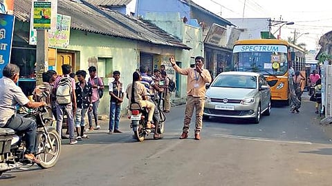 நாமக்கல் கோட்டை சாலையில் வாகனப் போக்குவரத்தை சீரமைக்கும் பணியில் வங்கி இணை மேலாளர் சபரிஷ் ஈடுபட்டார்.
