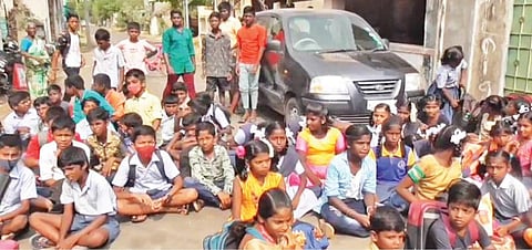ஆண்டியார்பாளையத்தில் பள்ளிக்கு சாலை வசதி கேட்டு மறியல் செய்த மாணவர்கள்.