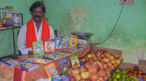 தஞ்சாவூரில் பழங்கள் வாங்குபவருக்கு புத்தகங்களை வழங்கும் பழ வியாபாரி காஜாமொய்தீன். படம்: ஆர்.வெங்கடேஷ்