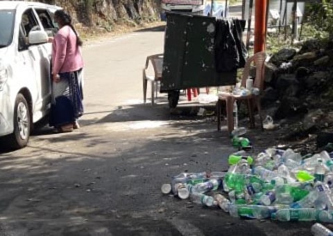 கொடைக்கானல் வெள்ளி நீர்வீழ்ச்சி அருகே சோதனையில் ஈடுபட்டுள்ள ஊழியர் மற்றும் பறிமுதல் செய்யப்பட்ட பிளாஸ்டிக் பாட்டில்கள். 