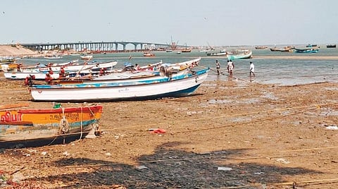 பாம்பனில் கடல் உள்வாங்குவதால் தரை தட்டி நிற்கும் நாட்டுப் படகுகள்.