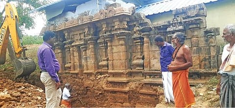 கீழப்பார்த்திபனூரில் உள்ள சிவன் கோயில் சுவர் அருகே தோண்டும் பணியில் ஈடுபட்டுள்ள பணியாளர்.