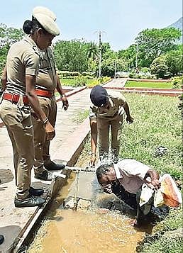 தி.மலை ஆட்சியர் அலுவலக முகப்பில் மண்ணெண்ணெய் ஊற்றிக் கொண்ட குணசேகரன் மீது, காவல்துறையினர்  தண்ணீரை ஊற்றினர்.