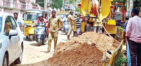 நாகர்கோவில் நீதிமன்ற சாலை விரிவாக்க பணியின்போது தரைத்தள கேபிள்கள் துண்டிக்கப்பட்டதால் இன்டர்நெட் சேவைகள் பாதிக்கப்பட்ட நிலையில் நேற்று சீரமைப்பு பணிகள் நடைபெற்றன.  சாலையின் அகலம் பாதியாக குறைந்ததால் வாகனங்கள் திணறியபடி செல்கின்றன. 	              படம்: எல்.மோகன்.