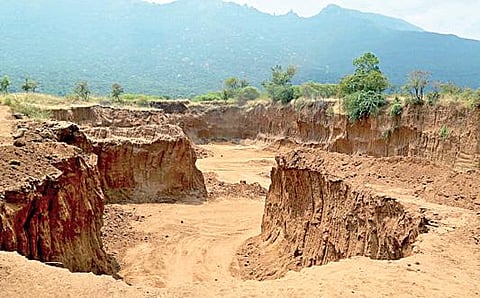 கோவை தடாகம் பகுதியில் மலை அடிவாரத்தில் பல அடி ஆழத்துக்கு தோண்டப்பட்ட செம்மண்.(கோப்பு படம்)