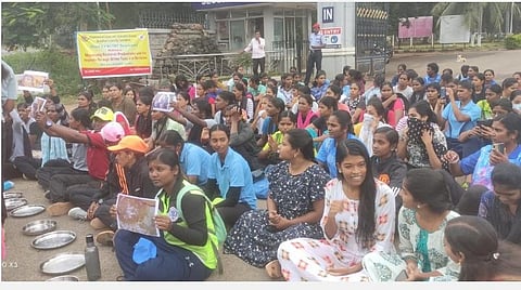 உணவின் தரம், தண்ணீர் பிரச்சினை சரிசெய்து தரக்கோரி கோவை பாரதியார் பல்கலைக்கழக நுழைவாயில் முன்பு தட்டுகளுடன் அமர்ந்து போராட்டத்தில் ஈடுபபட்ட மாணவிகள்.