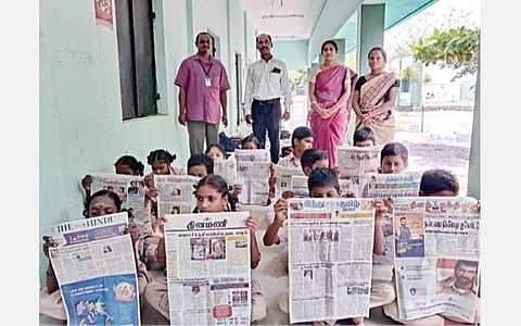 தாங்கள் படித்த நாளிதழ்களை உயர்த்திக் காண்பிக்கும் பள்ளி மாணவ, மாணவிகள். உடன் ஆசிரியர்கள்.