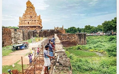 தஞ்சாவூர் பெரிய கோயிலின் முகப்பில் உள்ள அகழி கோட்டை சுவரை பழமை மாறாமல் புதுப்பிக்கும் பணியில் ஈடுபட்டுள்ள தொழிலாளர்கள்.படம்: ஆர்.வெங்கடேஷ்