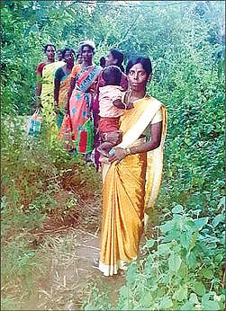 சாலை வசதி இல்லாததால் மலை வழியாக நடந்து செல்லும் பெண்கள்.