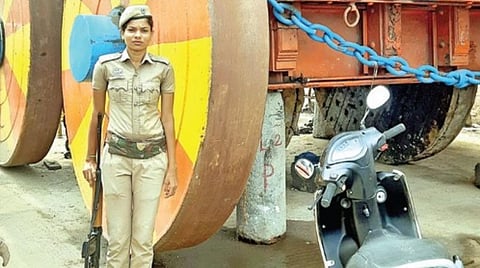 பெரிய தேர் முன்பு துப்பாக்கி ஏந்திய பெண் காவலர் பாதுகாப்பு பணியில் ஈடுபட்டுள்ளார்.