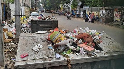 மதுரை | நிரம்பி வழியும் குப்பை தொட்டிகளால் தூர்நாற்றத்தை நுகர்ந்தவாறே பள்ளி செல்லும் மாணவர்கள்