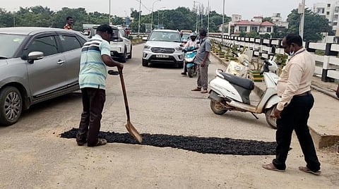பள்ளங்களை சீரமைக்கும் மாநகராட்சி பணியாளர்கள்
