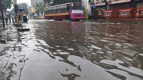 சாலை படிந்த மணலை அகற்றும் ஊழியர்கள்