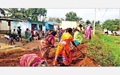 சிமென்ட் சாலை அமைக்க நில அளவீடு பணியை தொடங்க வலியுறுத்தி, மண் சாலையை சீரமைக்கும் போராட்டத்தில் ஈடுபட்ட நாரல்சந்தம்பட்டி கிராம பெண்கள்.