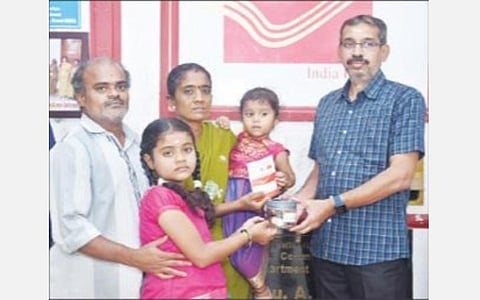 தேசிய பெண் குழந்தைகள் தினத்தை முன்னிட்டு சிறுமி மோனிகாவிடம் தபால் நிலைய அதிகாரி செல்வமகள் சேமிப்பு புத்தகத்தை வழங்கினார்.
