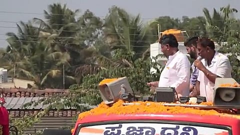 பேரணியின்போது 500 ரூபாய் நோட்டை வீசும் டி.கே.சிவகுமார்.