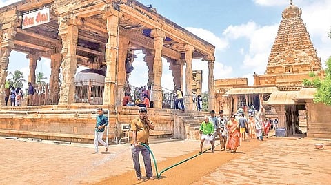தஞ்சாவூர் பெரிய கோயிலில் வெயிலின் தாக்கம் அதிகம் இருந்ததால் கோயில் வளாகம் முழுவதும் நேற்று தண்ணீர் தெளித்து வெப்பத்தை தணிக்கும் பணியில் ஈடுபட்டுள்ள கோயில் பணியாளர். படம் ஆர்.வெங்கடேஷ்