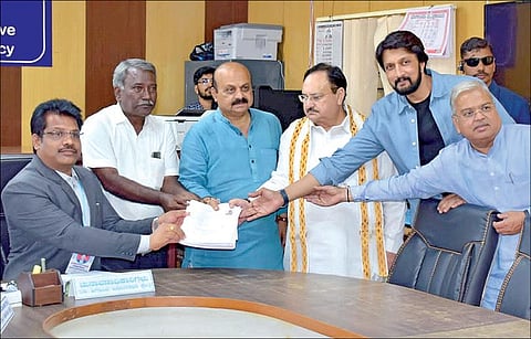 வரும் மே 10-ம் தேதி நடைபெறவுள்ள கர்நாடக சட்டப்பேரவைத் தேர்தலில் ஷிகோன் தொகுதியில் முதல்வர் பசவராஜ் பொம்மை போட்டியிடவுள்ளார். இதற்காக நேற்று ஷிகோன் தொகுதியில் அவர் வேட்புமனு தாக்கல் செய்தார். உடன் பாஜக தேசியத் தலைவர் ஜே.பி. நட்டா, கன்னட நடிகர் கிச்சா சுதீப் உள்ளனர். படம்: பிடிஐ