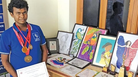 தான் வரைந்த ஓவியங்கள் , விருதுகளுடன் யோகேஷ் கண்ணன்.