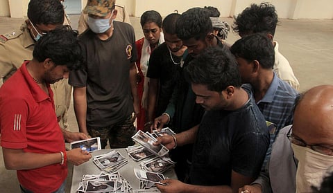 உயிரிழந்தவர்களின் புகைப்படங்களைக் கொண்டு அடையாளம் காண முயலும் குடும்பத்தினர் | இடம்: பாலசோர்