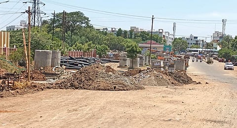 தென்னூர் உழவர் சந்தை  மைதானத்தில் குவித்து வைக்கப்பட்டிருக்கும் ஒப்பந்த நிறுவனத்தின் கட்டுமானப் பொருட்கள்.