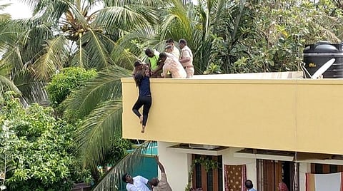 காரைக்குடி கலைஞர் சாலையில் மாடியில் இருந்து குதிக்க முயன்ற மாணவி காவியா ஸ்ரீயை காப்பாற்றிய போலீஸார், தீயணைப்புத்துறையினர்.