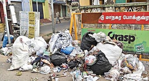 தூய்மைப் பணியாளர்கள் வேலை நிறுத்தம் காரணமாக, ஈரோடு ராமசாமி வீதியில் தேங்கியுள்ள குப்பை.