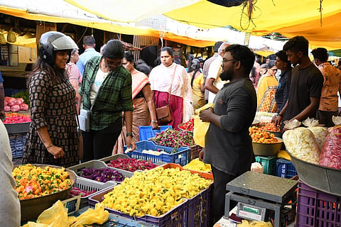 கோவை பூமார்க்கெட்டில் விற்பனைக்காக வைக்கப்பட்டிருந்த பூக்களை வாங்கும் வாடிக்கையாளர்கள். |  படம்: ஜெ.மனோகரன்.