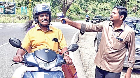 தேனி மாவட்டம் குமுளி மலையடிவாரம் லோயர்கேம்ப் பகுதியில் கேரளாவில் இருந்து இருசக்கர வாகனத்தில் வந்தவருக்கு மருத்துவ சோதனை செய்யும் சுகாதாரத் துறையினர்.