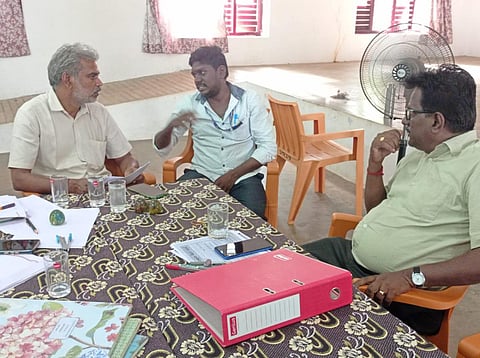 கைது செய்யப்பட்ட ஆசிரியர் (நடுவில் இருப்பவர்)