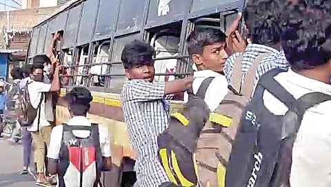 பேருந்தில் தொங்கியபடி செல்லும் மாணவர்கள்.