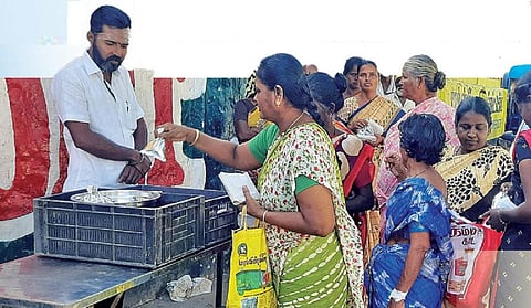 உடுமலை அரசு மருத்துவமனை முன் மணிகண்டன் வைத்திருந்த உணவை எடுத்துச் செல்லும் பொதுமக்கள்.