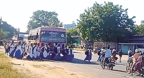 திருப்பராய்த்துறையில் திருச்சி - கரூர் தேசிய நெடுஞ்சாலையில் சாலையை கடக்கும் மாணவ, மாணவிகள்