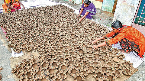 தஞ்சாவூர் கீழவாசல் பகுதியில் கார்த்திகை திருவிழாவுக்காக அகல் விளக்குகளை வெயிலில் உலர வைக்கும் பணியில் ஈடுபட்ட தொழிலாளர்கள். | படங்கள்: ஆர்.வெங்கடேஷ்