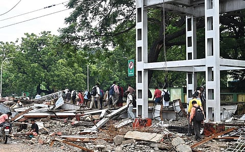 கோட்டை ரயில் நிலையத்தில் குவித்து வைக்கப்பட்டுள்ள கட்டுமானப் கழிவுகளுக்கு  மத்தியில் சிறிய பாதையை தேடி நடந்து செல்லும் தலைமைச் செயலக ஊழியர்கள். | படங்கள்: எஸ்.சத்தியசீலன்