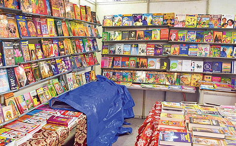 திருச்சியில் நடைபெறும் புத்தகத் திருவிழா அரங்கின் மேற்கூரை மழைக்கு ஒழுகுவதால், புத்தகங்கள் நனையாமல் இருக்க ஒரு அரங்கில் தார்ப்பாய்போட்டு புத்தகங்களை மூடி வைத்துள்ளனர். | படங்கள்: ர.செல்வமுத்துகுமார்